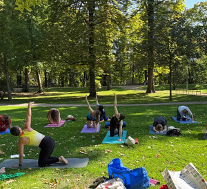 Menschen die im Park Yoga machen